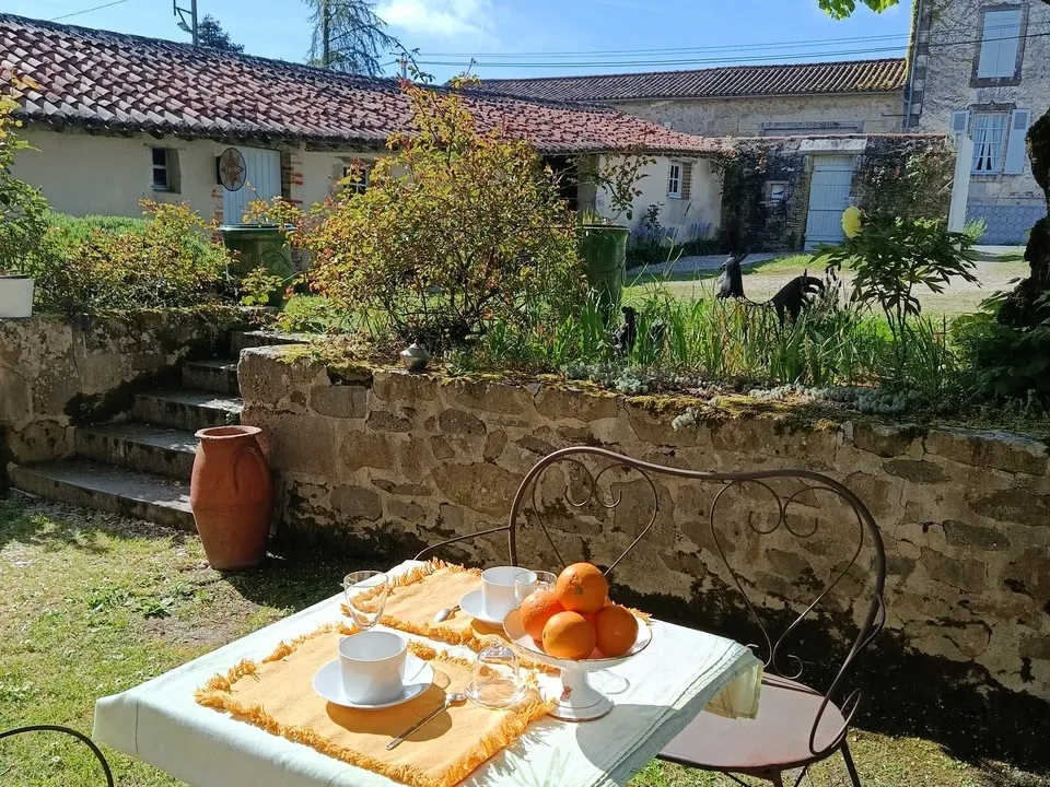 la terrasse avec la table et le couvert pour le petit déjeuné sous le tilleul de ce logis avec chambre d'hôtes Vendée 85